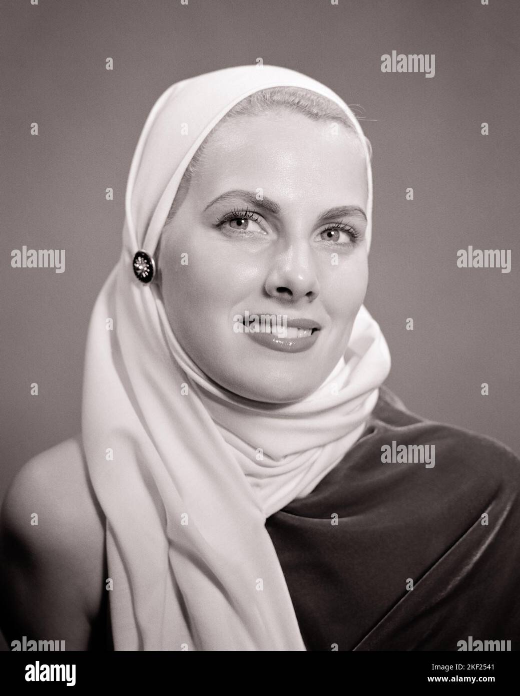 1940s 1950s GLAMOROUS BLONDE WOMAN PORTRAIT WEARING WHITE HEAD SCARF COWL HOOD - g381 HAR001 HARS LIFESTYLE FEMALES STUDIO SHOT HEALTHINESS HOME LIFE COPY SPACE LADIES MAKEUP PERSONS CLOTH PROFESSION CONFIDENCE COVERING EXPRESSIONS B&W OCCUPATION COSMETICS MAKE-UP HEAD AND SHOULDERS CHEERFUL STYLES SOPHISTICATED CAREERS OCCUPATIONS SMILES COWL CONCEPTUAL JOYFUL STYLISH PLEASANT CHIC FASHIONS GLAMOROUS YOUNG ADULT WOMAN BLACK AND WHITE CAUCASIAN ETHNICITY HAR001 HEADSCARF OLD FASHIONED Stock Photo