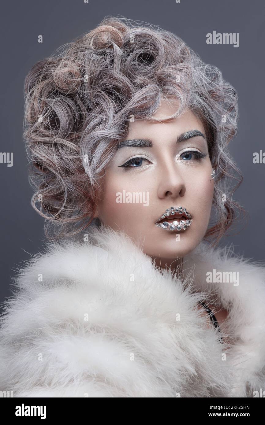 Beautiful fashion model girl with snow hair style and make up. Winter queen. Winter beauty face. Stock Photo