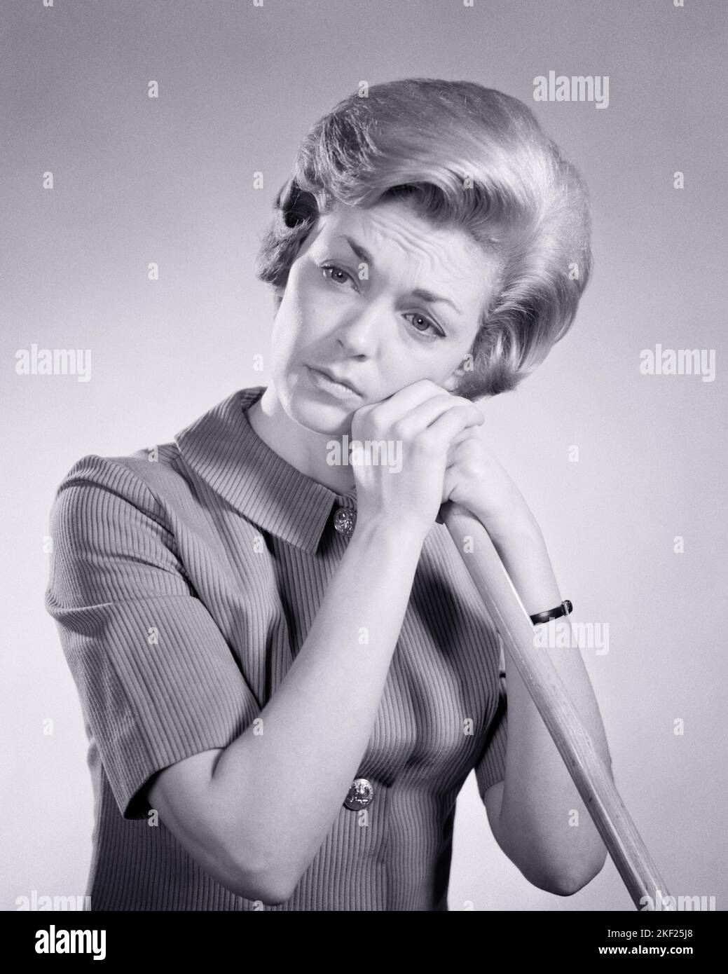 1960s SAD TIRED WOMAN HOUSEWIFE LEANING ON THE HANDLE OF A BROOM OR MOP - g5865 HAR001 HARS PERSONS BROOM NERVOUS AILMENT TROUBLED B&W CONCERNED SADNESS HOMEMAKER ANXIETY DREAMS SUFFERING HOMEMAKERS OVERWHELMED DESPAIR HOUSEWIVES MOOD MENTAL HEALTH CONCEPTUAL GLUM HANDLE OR POOR HEALTH TENSION AILING MID-ADULT MID-ADULT WOMAN MISERABLE BLACK AND WHITE CAUCASIAN ETHNICITY HAR001 MENTAL ILLNESS OLD FASHIONED Stock Photo