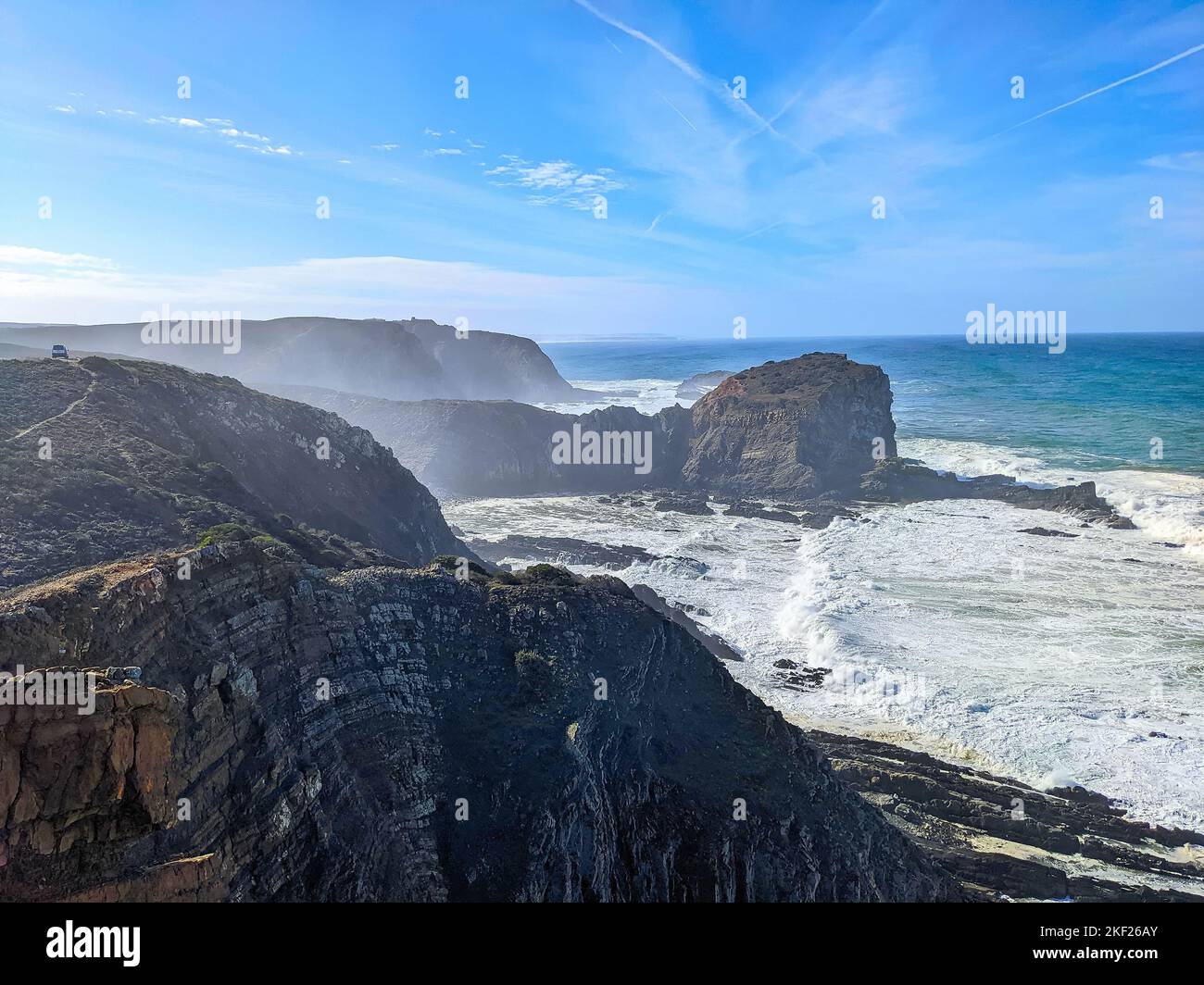 Seascape with Atlantic ocean rocky cliffs, bright sunshine, clear blue sky, Aljezur, Portugal Stock Photo