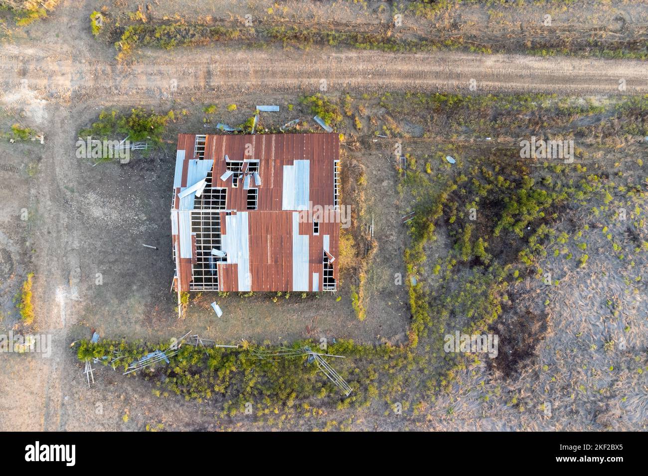 Aerial view over destroyed house with broken roof after tornado or storm. Top down, drone shot Stock Photo