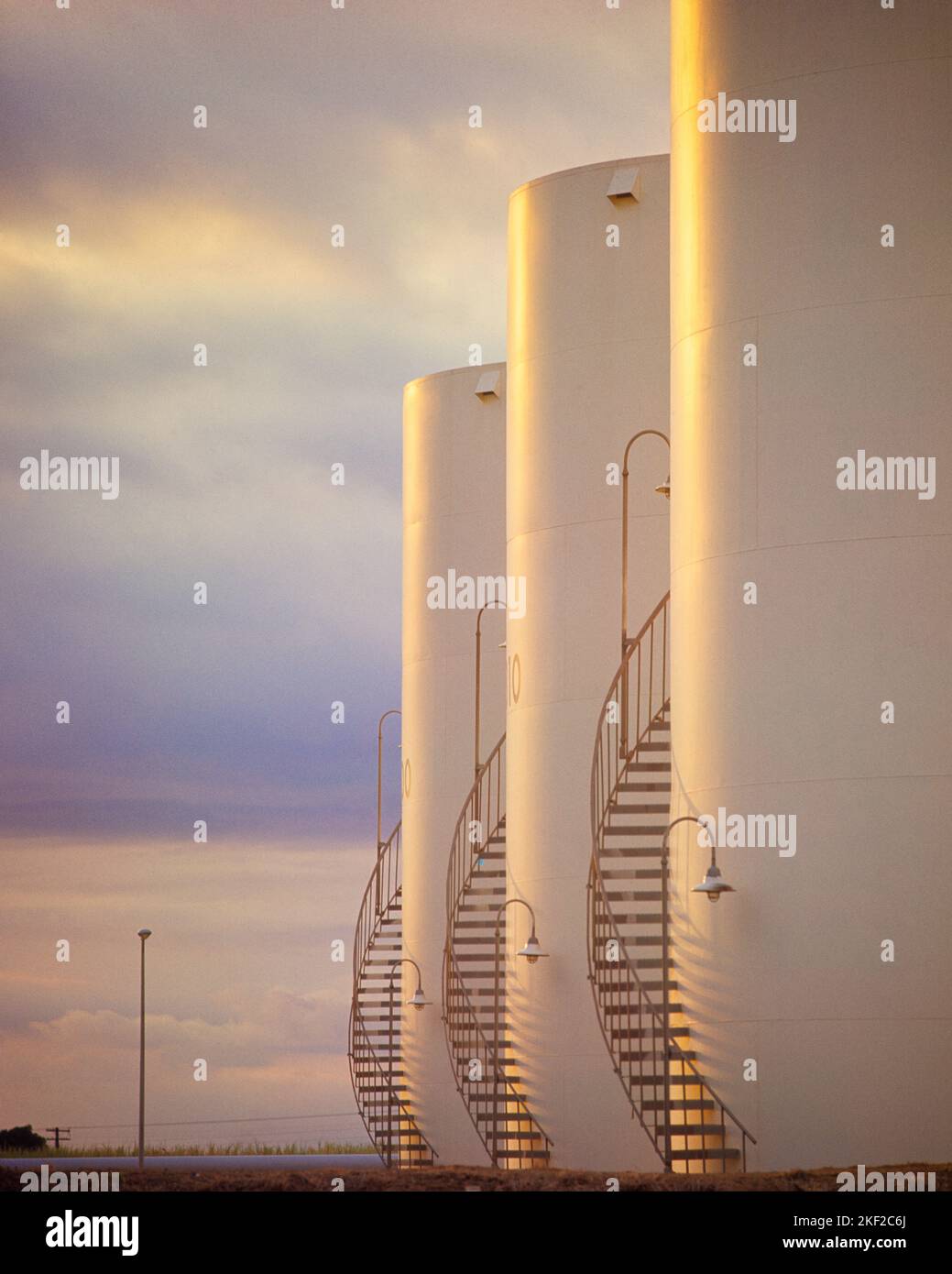 1960s 1970s THREE WHITE ROUND OIL STORAGE TANKS WITH CURVED STAIRWAY