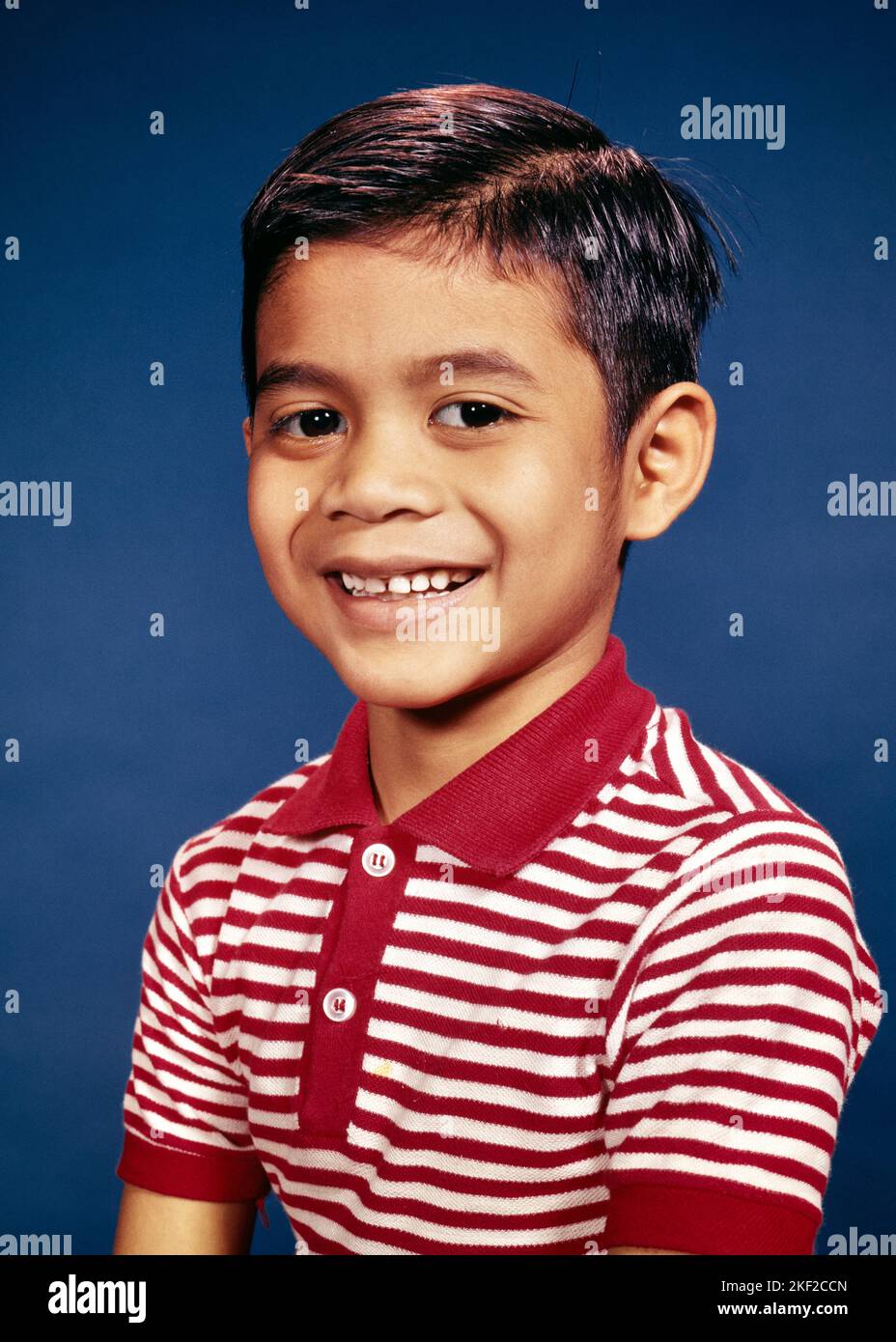 1960s PORTRAIT OF MULTIRACIAL BOY SMILING WEARING RED AND WHITE