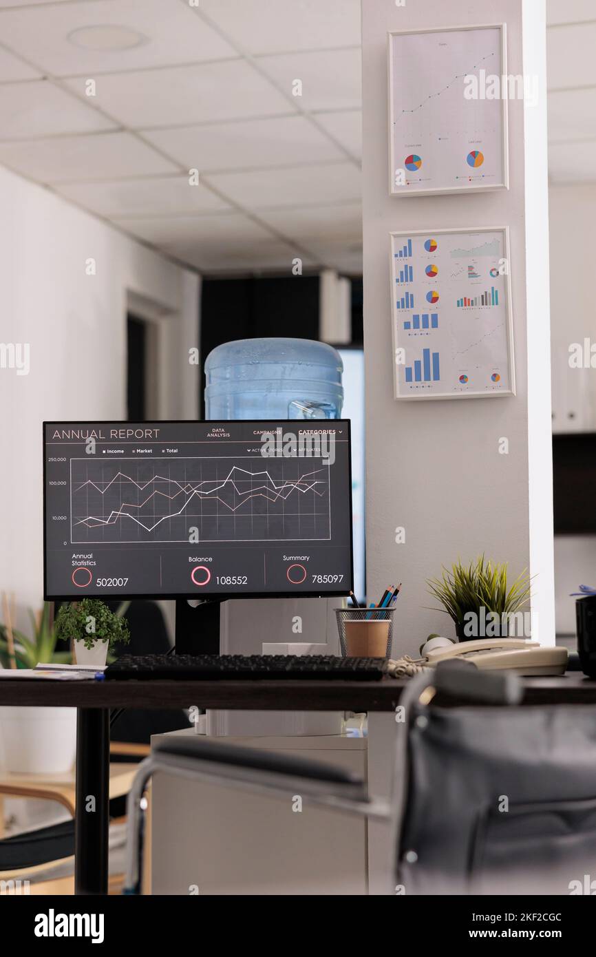 Finance employee desk of an auditing and financial consulting company, disabled friendly office. Statistical charts hanging on the wall, on desk landline phone and working materials. Stock Photo