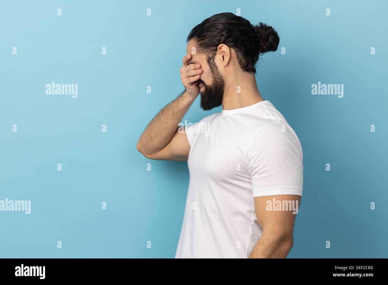 Don't want to look at this. Side view of scared man with beard wearing ...