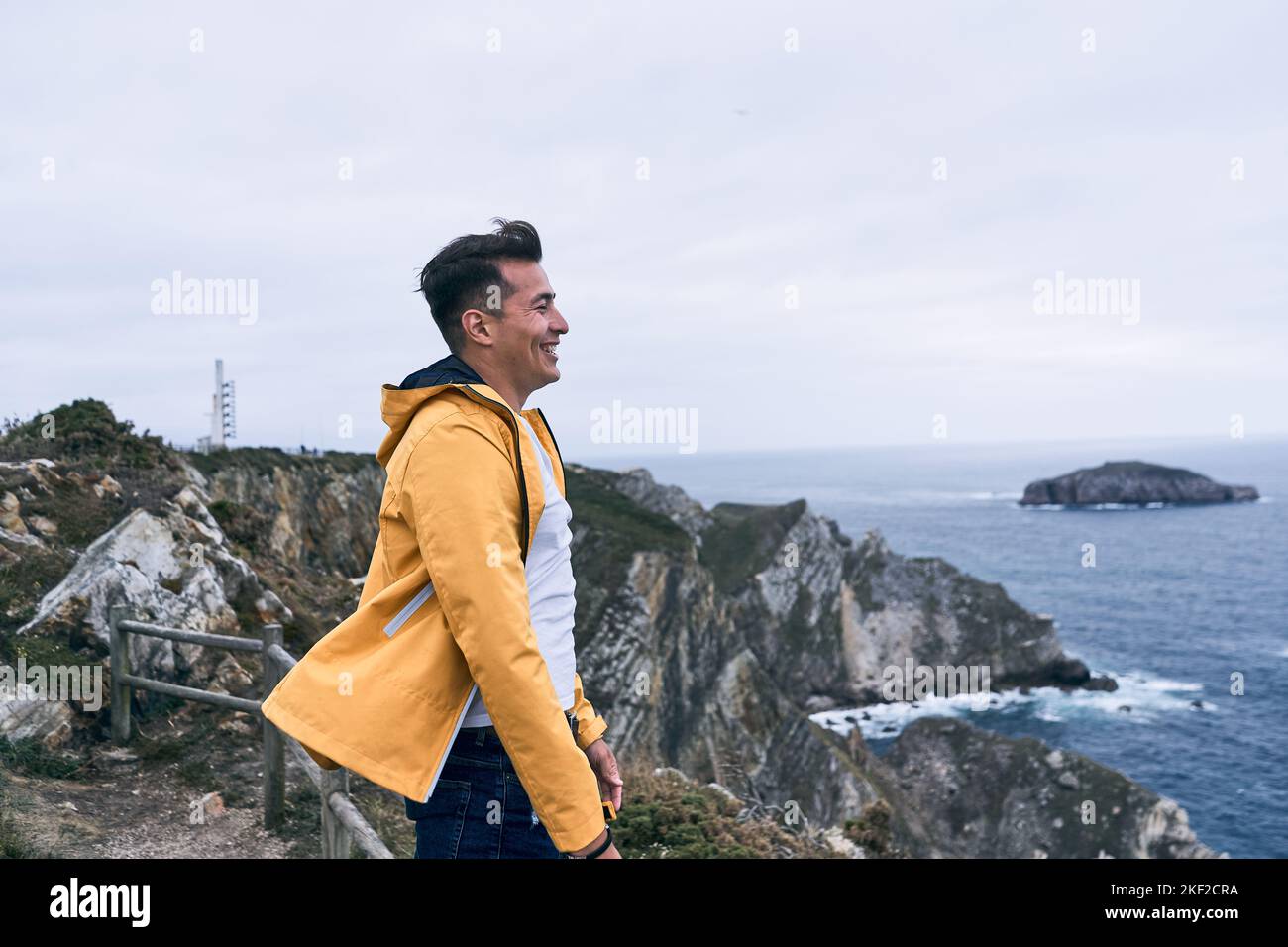 latin young man in white tshirt and yellow jacket smiling calm and