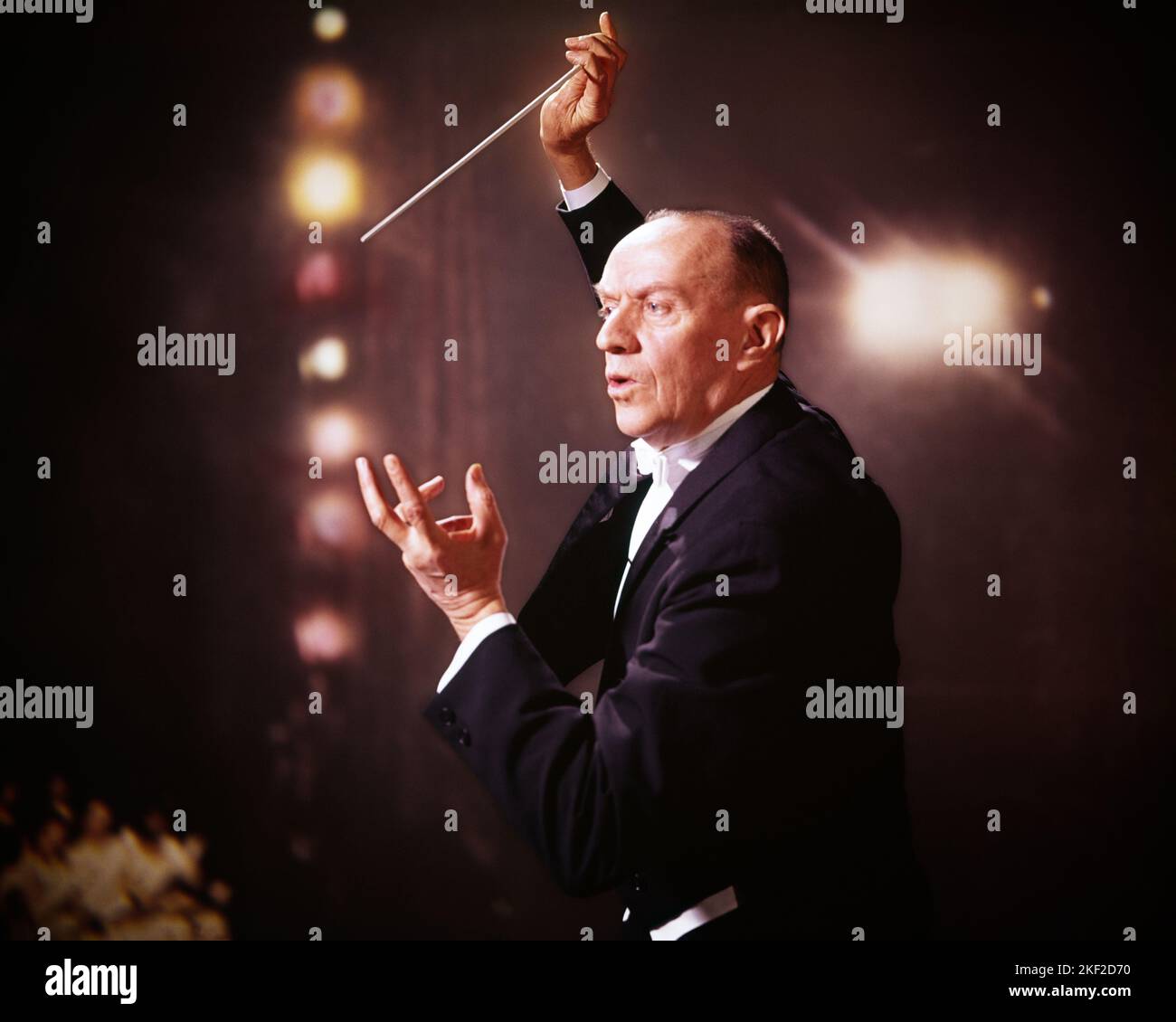 1970s MIDDLE-AGED MAN ORCHESTRA CONDUCTOR CONDUCTING A SYMPHONY WEARING A TUXEDO BRIGHT LIGHTS BEHIND HIM DEMONSTRATIVE GESTURES - km1872 HAR001 HARS JOBS STUDIO SHOT COPY SPACE HALF-LENGTH PERSONS INSPIRATION MALES ENTERTAINMENT SPIRITUALITY MIDDLE-AGED MIDDLE-AGED MAN GOALS SKILL OCCUPATION SKILLS BRIGHT SYMPHONY AUTHORITY CONDUCTING GESTURES OCCUPATIONS MUSICAL INSTRUMENT CONNECTION CONCEPTUAL STYLISH HIM PASSIONATE CAUCASIAN ETHNICITY DEMONSTRATIVE EXPRESSIVE HAR001 OLD FASHIONED Stock Photo
