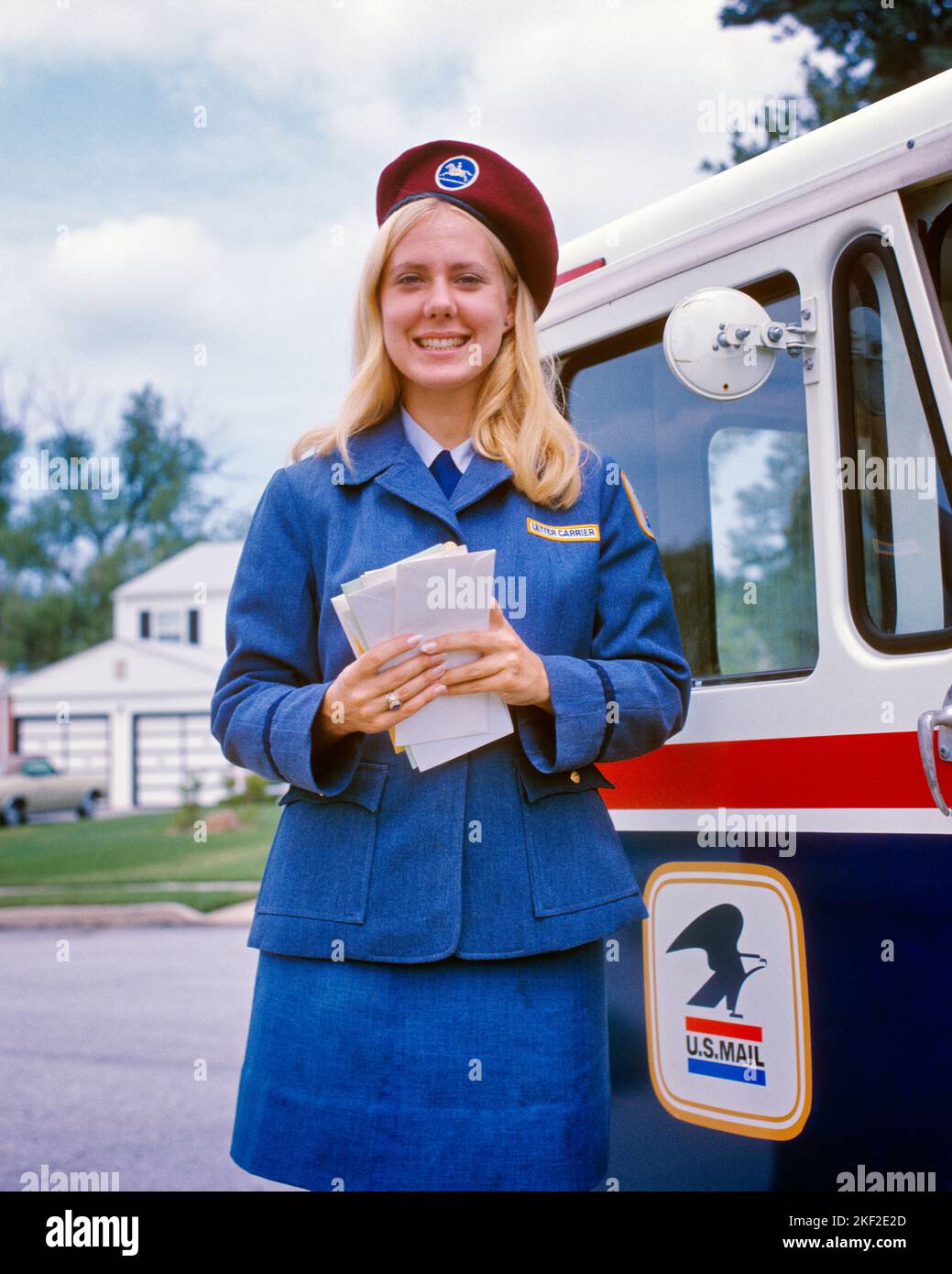1970s PORTRAIT SMILING BLONDE FEMALE MAILMAN HOLDING ENVELOPES WEARING UNIFORM & CAP STANDING BY POSTAL USPS DELIVERY VEHICLE - kp2139 HAR001 HARS 1 STYLE COMMUNICATION VEHICLE YOUNG ADULT PLEASED JOY LIFESTYLE SATISFACTION FEMALES JOBS HEALTHINESS UNITED STATES COPY SPACE FRIENDSHIP HALF-LENGTH LADIES PERSONS POSTAL UNITED STATES OF AMERICA CONFIDENCE NORTH AMERICA EYE CONTACT NORTH AMERICAN SKILL OCCUPATION HAPPINESS SKILLS CHEERFUL ENVELOPES CUSTOMER SERVICE LABOR PRIDE EMPLOYMENT OCCUPATIONS SMILES MAILING JOYFUL MAILMAN STYLISH EMPLOYEE USPS COOPERATION UNITED STATES POSTAL SERVICE Stock Photo
