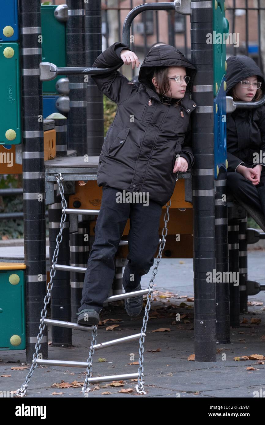 A orthodox yeshiva student spends recess tangled in a ladder in a park in Brooklyn, New York. Stock Photo