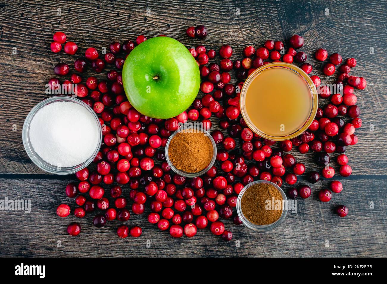 Apple Cranberry Sauce with Cider & Cinnamon on a Wood Background: Fresh cranberries, apples, and other ingredients for cranberry sauce Stock Photo