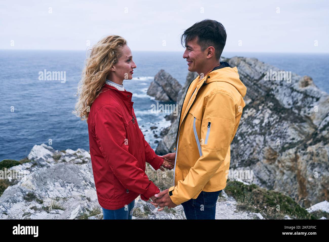 latin boy and caucasian girl in red and yellow jacket half length