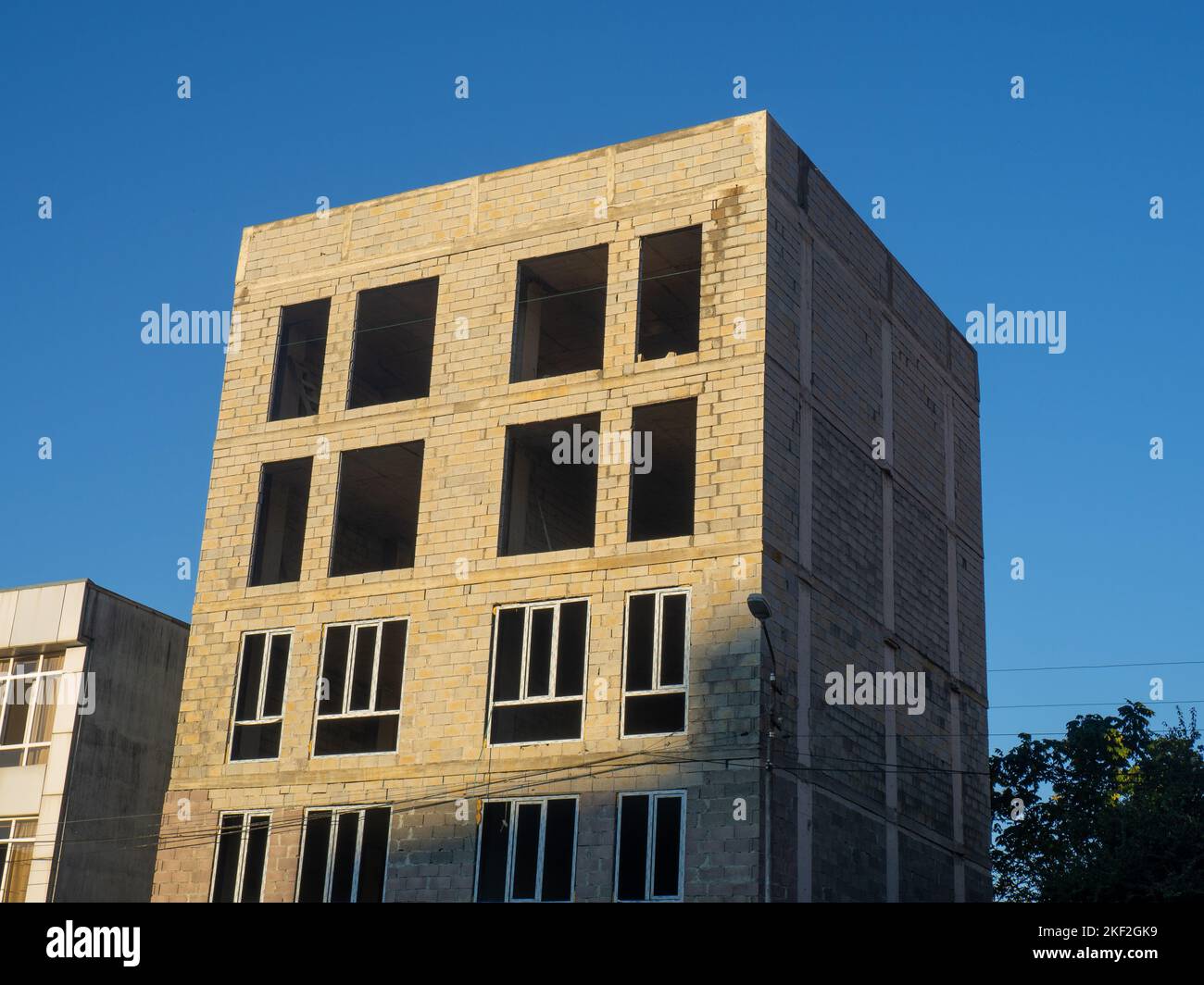 A five-story concrete block house under construction. The skeleton of the house. Unfinished construction of a small residential building. Southern arc Stock Photo