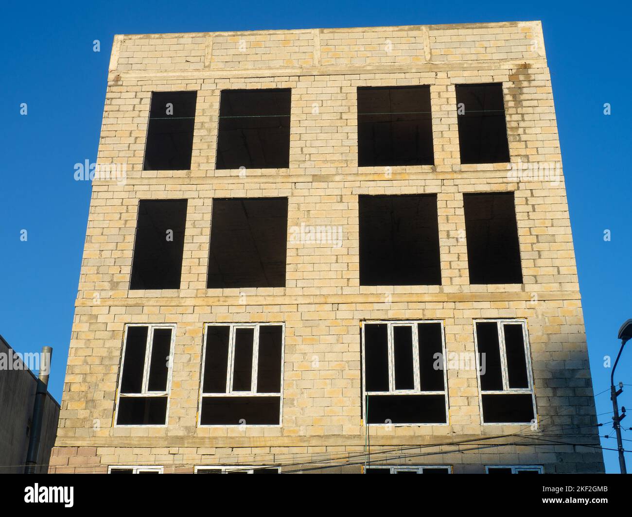 A five-story concrete block house under construction. The skeleton of the house. Unfinished construction of a small residential building. Southern arc Stock Photo