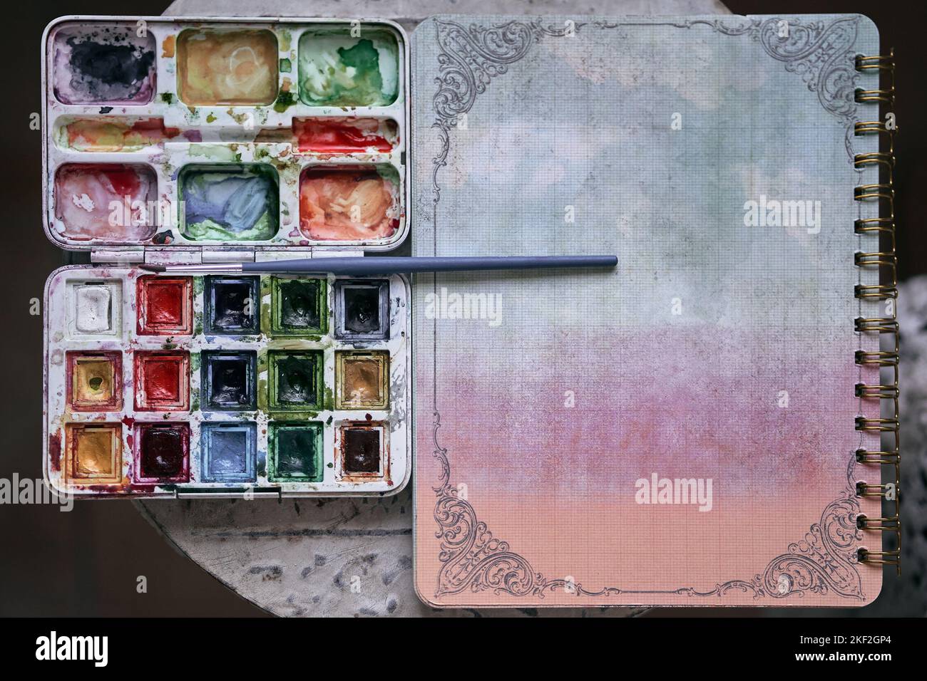 closeup of a ring binder box of watercolors with paint of many colors and small fine brush Stock Photo