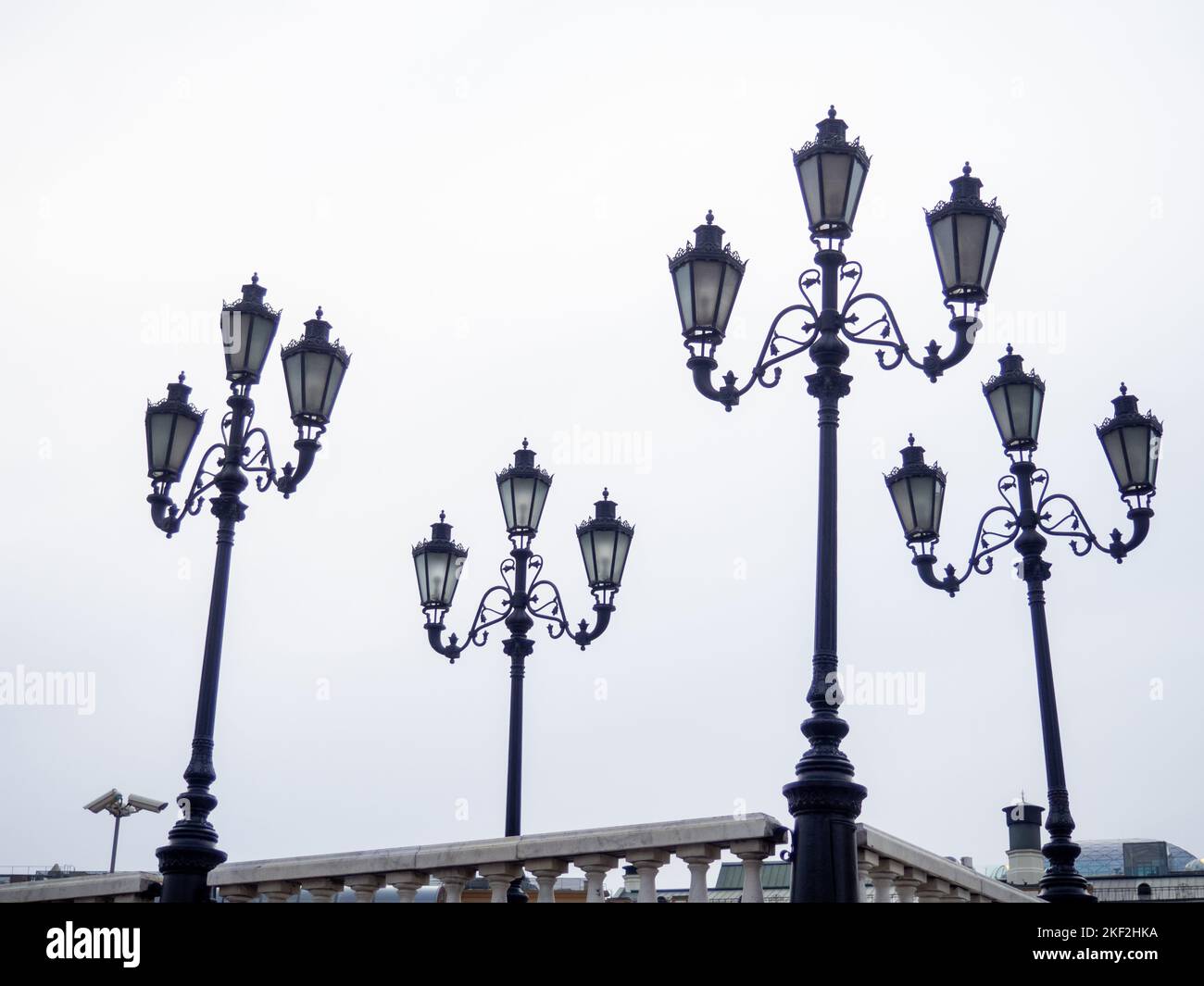 Old lampposts against the gray sky. Park lighting. Lanterns during the day. Moscow Lanterns Stock Photo