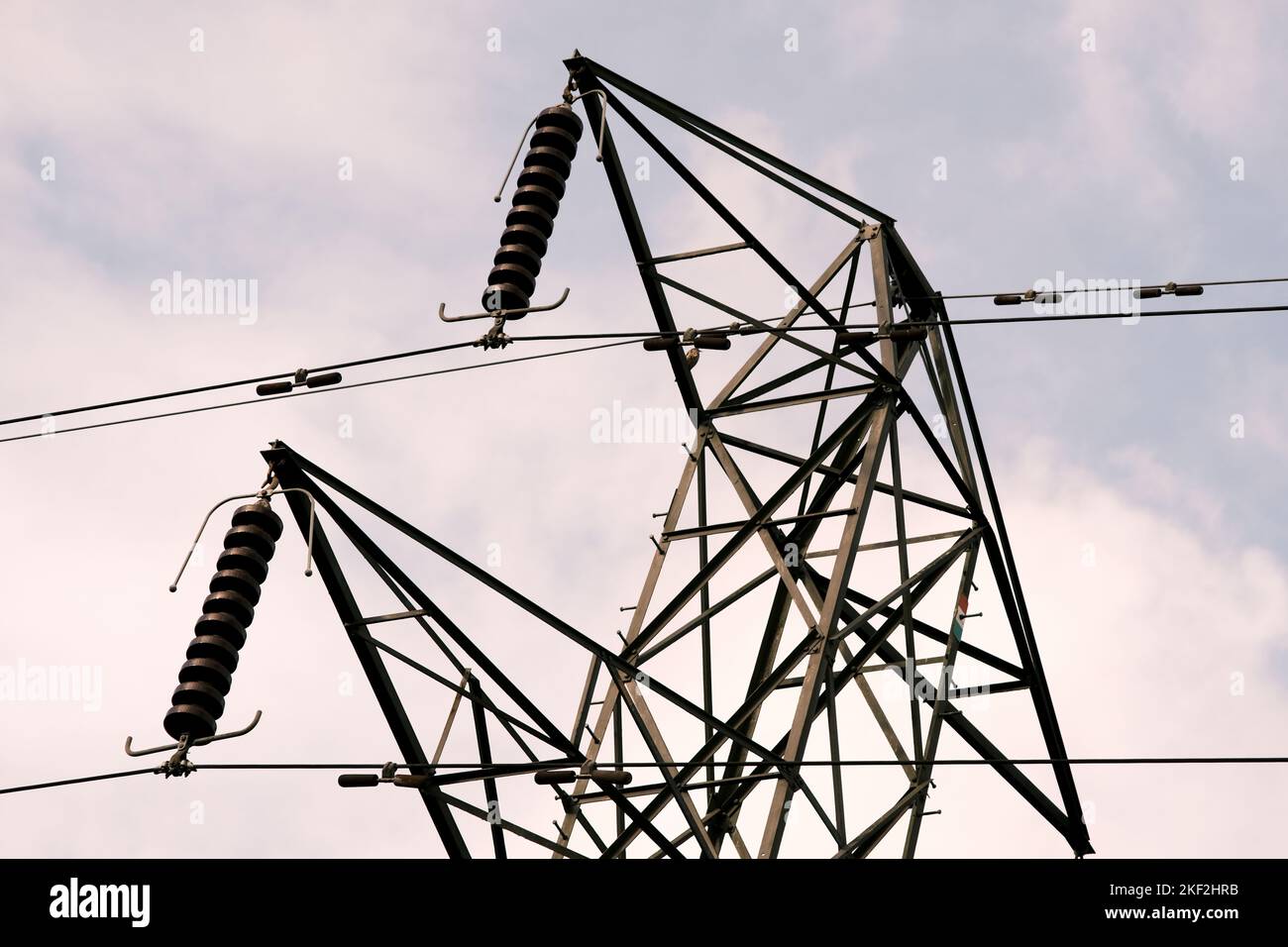 Looking up at electrical pylon in Aberdare, South Wales. Grey, dull metal structure with cloudy sky in background. Power supply and infrastructure. Stock Photo