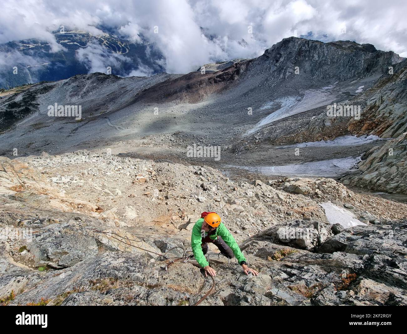 Via Ferrata mountain hike climber man climbing on steep rock in Whistler, BC, Canada travel destination. Summer adventure Stock Photo