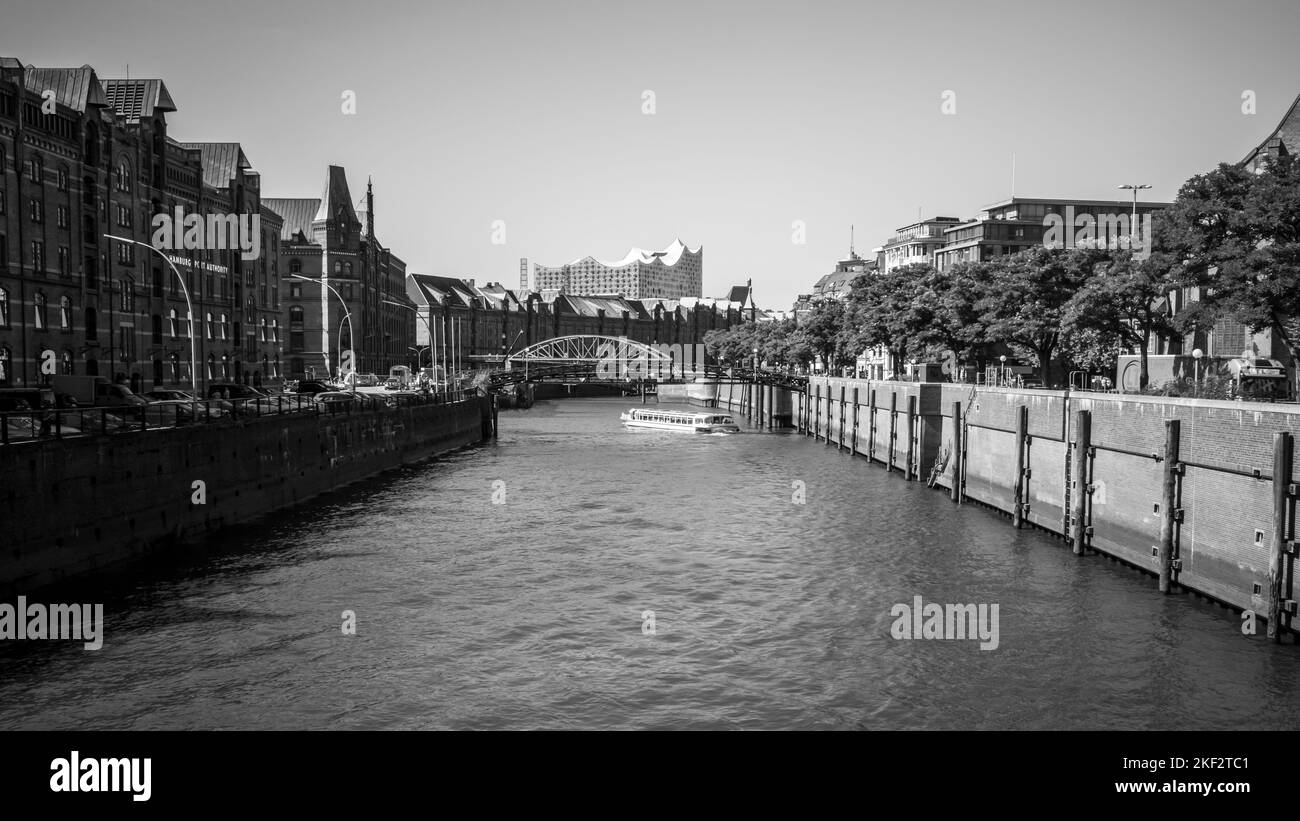 A gray-scale shot of the river with building on the side in Hamburg, Germany Stock Photo