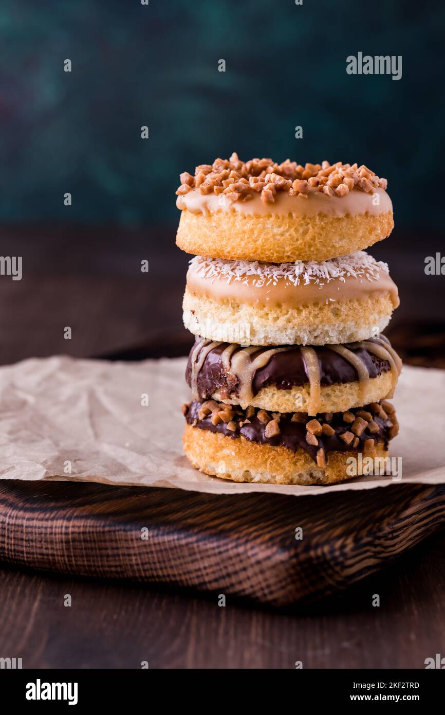 A close up of a stack of homemade donuts with various toppings. Stock Photo