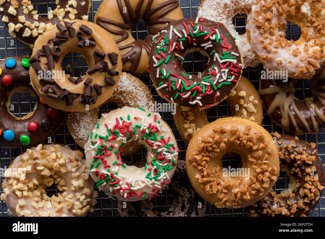 Top down view of a pile of assorted homemade donuts with different toppings. Stock Photo