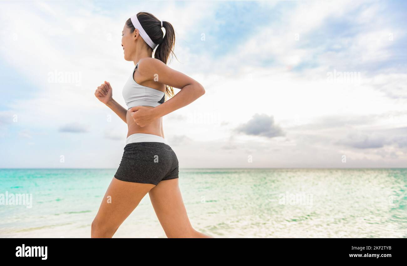 Healthy runner girl jogging on beach morning workout with sun and tropical ocean background. Training in the Caribbean, summer holidays. Fitness and Stock Photo