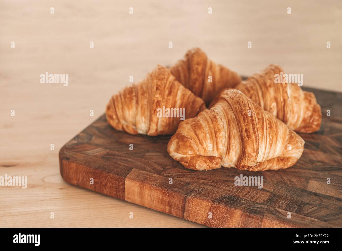 Croissants fresh baked pastries from french bakery. 4 viennoiseries on wooden board. Breakfast food from France baking culture. Flaky warm croissant Stock Photo