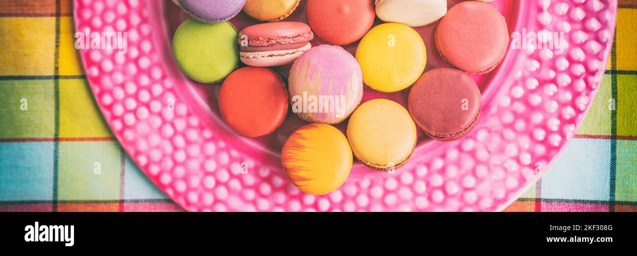 Many macarons at bakery in gift box. Panoramic banner of french sweet desserts top view Stock Photo