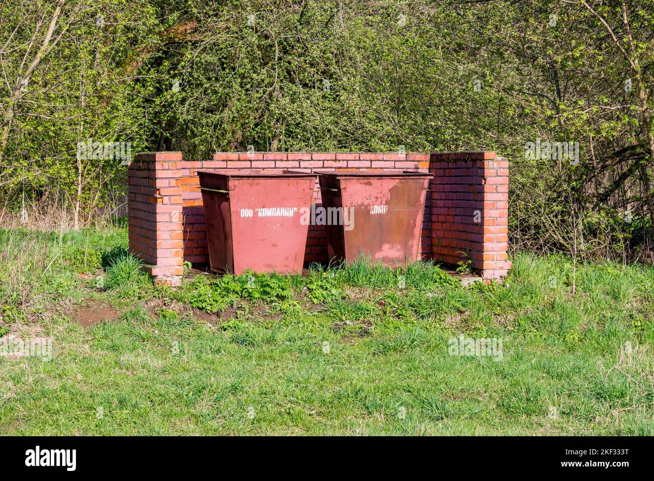 Garbage cans in nature in a brick shelter, garbage disposal site: Russia - May 2020 Stock Photo