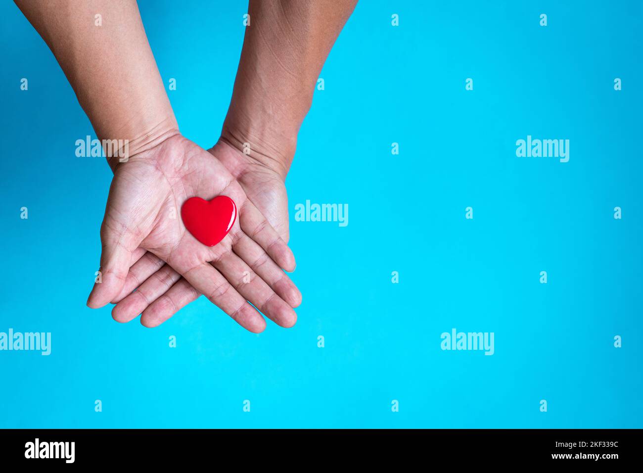 Heart health concept. Red heart shape on the palm of hand. Top view, copy space. Stock Photo