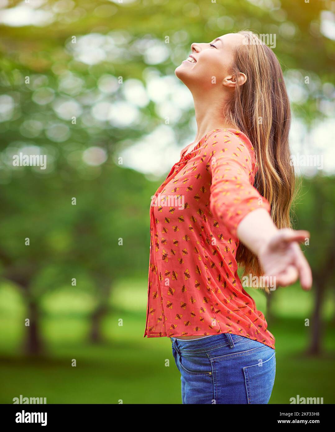 Being outside uplifts the soul. a carefree young woman standing with her arms outstretched in