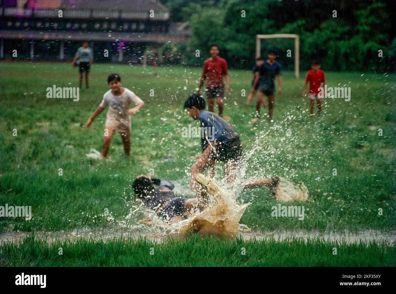 Boys playing football soccer in rain Mumbai Stock Photo Alamy