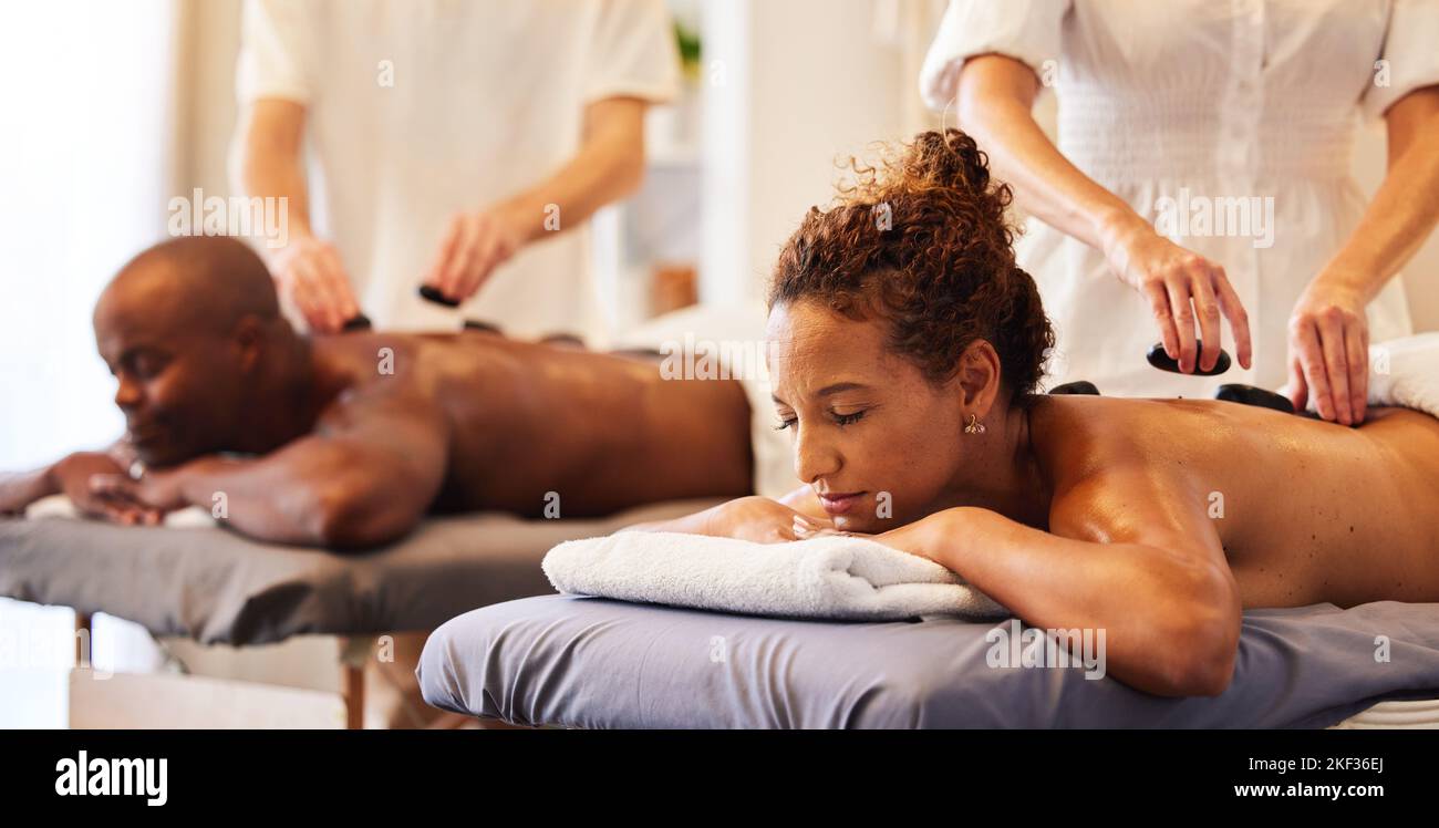 Couple massage, rock or spa therapist for relax, luxury or wellness treatment for health, self care or zen at resort. Healthcare, beauty salon or Stock Photo