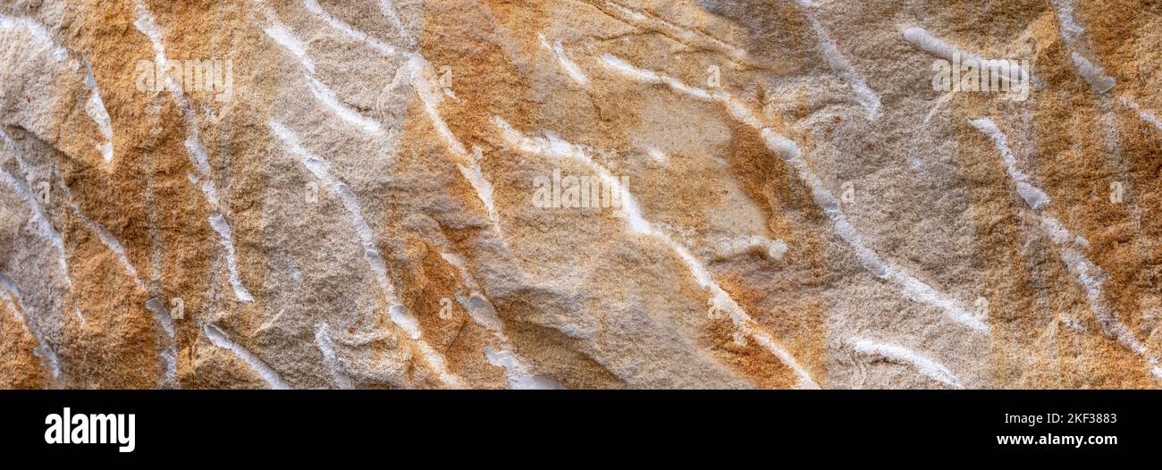 Rough uneven sandstone surface in gray and brown with white lines Stock Photo
