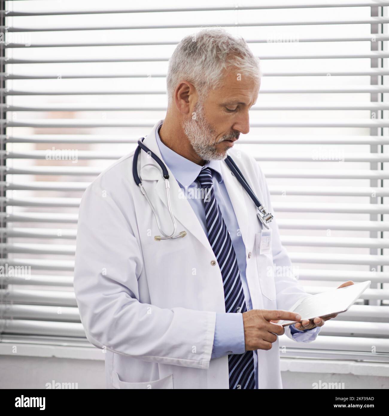 Technology is vital for advancing healthcare. a mature male doctor using a digital tablet. Stock Photo
