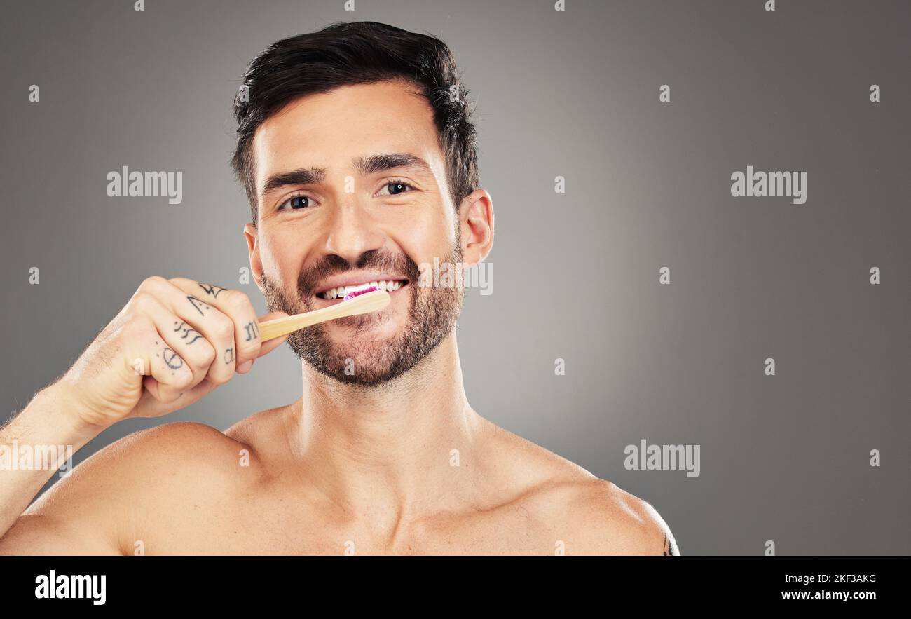 Brushing teeth, bamboo and man in studio for dental, dentist and mouth
