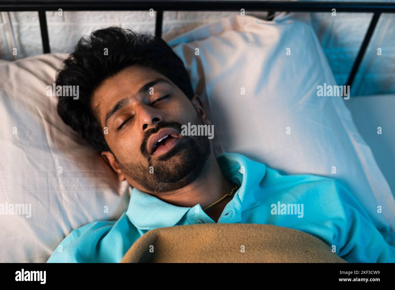 close up shot of man sleeping by snoring with mouth open during night