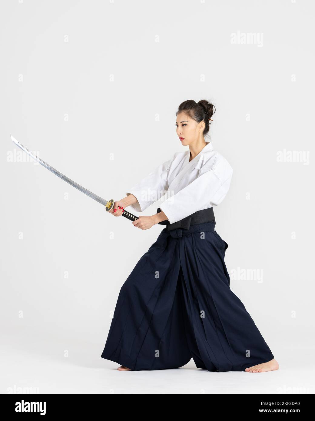 Aikido master woman in traditional samurai hakama kimono with black belt with sword katana on white background. Healthy lifestyle and sports concept Stock Photo Alamy