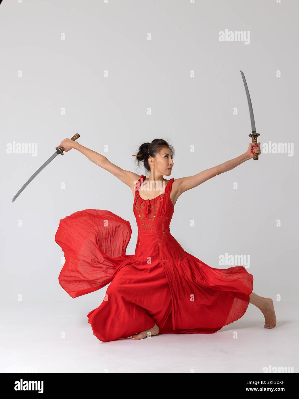 Aikido master woman in red dress with sword, katana on white background. Healthy lifestyle and sports concept. Stock Photo