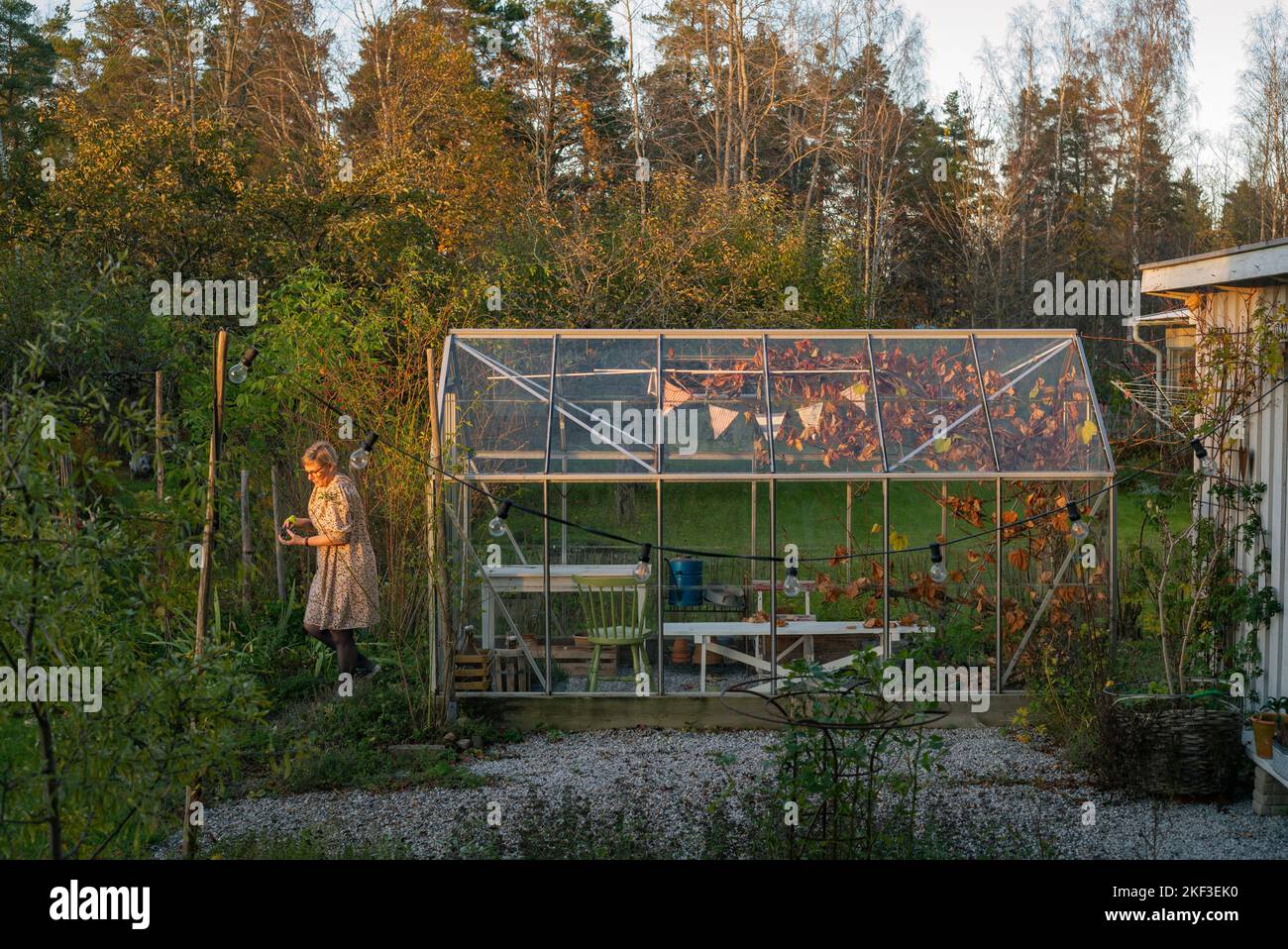 Woman walking by her greenhouse Stock Photo