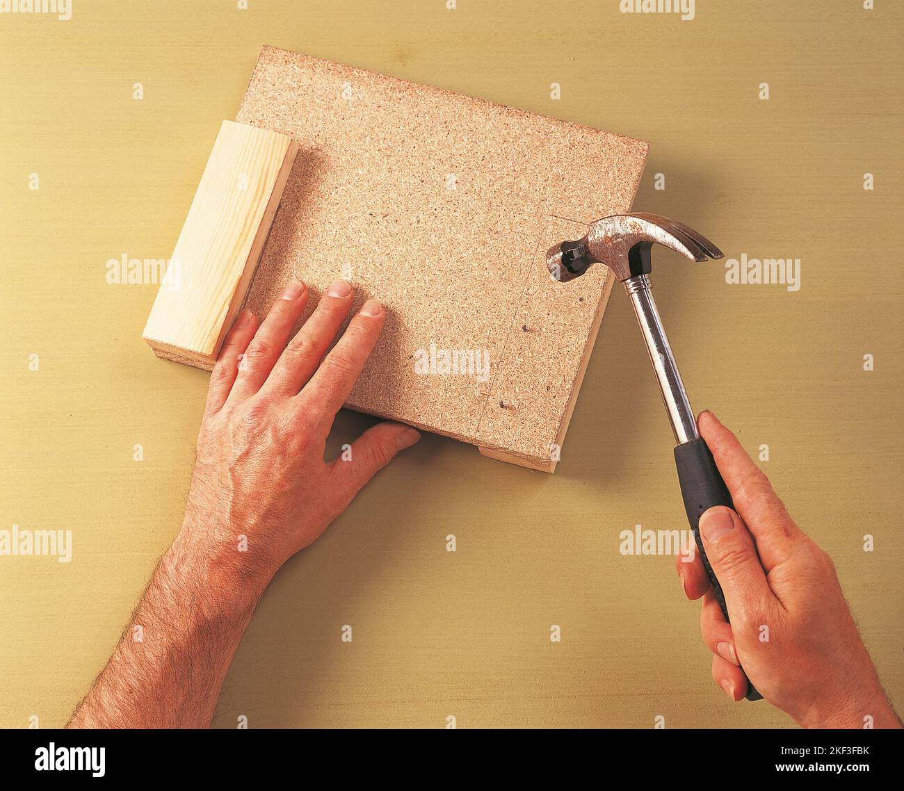 Affixing a piece of timber to the chipboard Stock Photo - Alamy