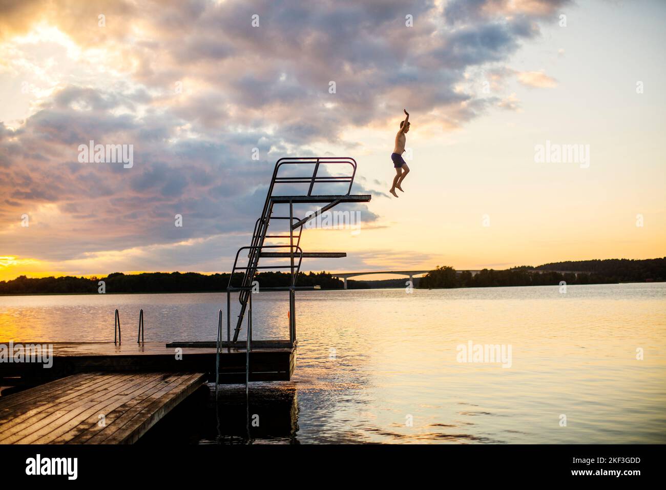 Boy diving into lake at sunset Stock Photo Alamy