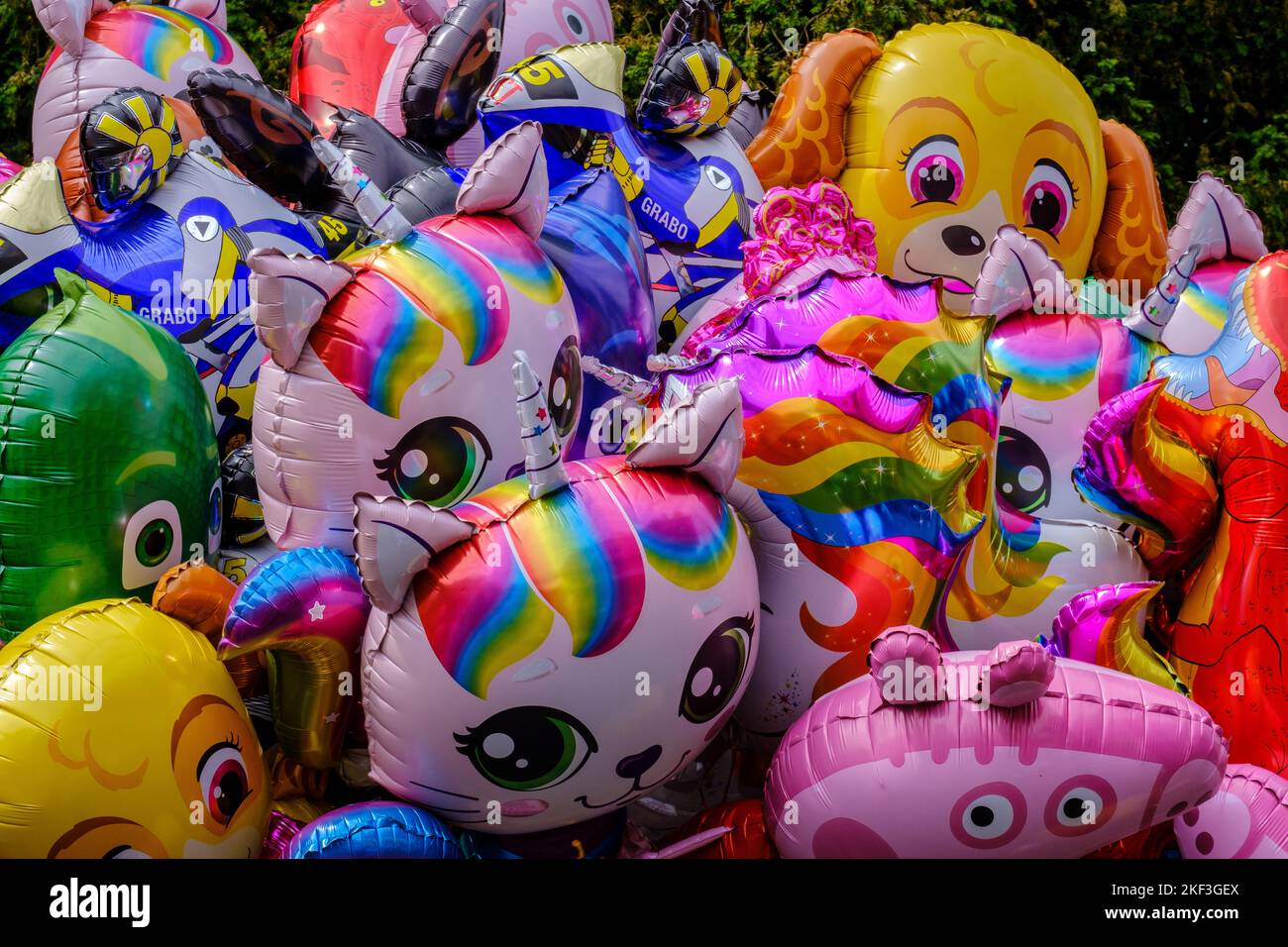 Detail of bunch of colourful Helium Cartoon Characters Balloons. Unicorns, dogs and other characters. Stock Photo