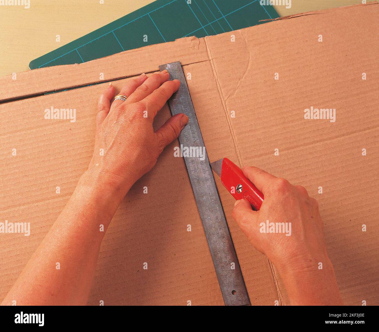 Cutting a piece of a cardboard with utility knife Stock Photo Alamy