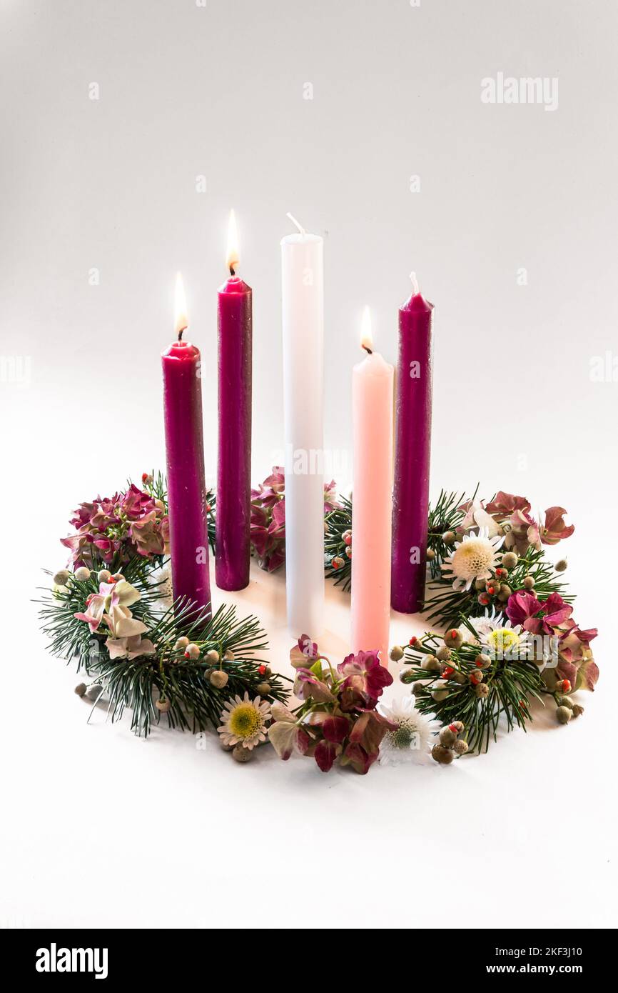 3 purple candles, 1 pink and one white candle on decorated and adorned