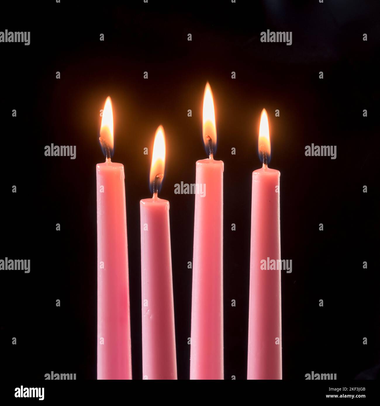 4 burning pink advent candles on black background Stock Photo Alamy