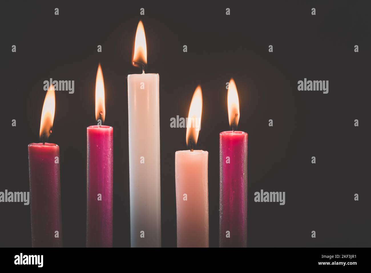 3 purple candles, 1 pink and one white candle burning, advent wreath