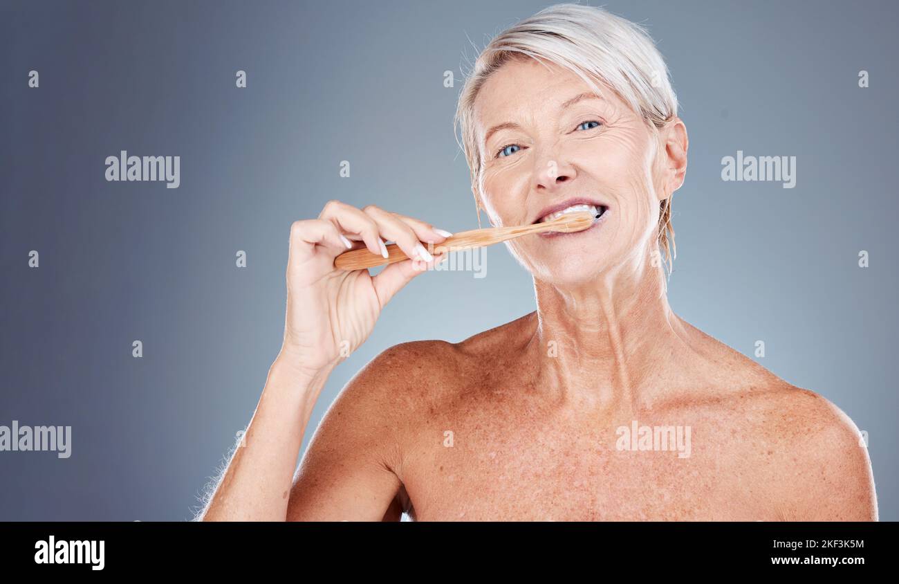 Brushing teeth, portrait and senior woman in studio for dental, mouth and tooth wellness with product marketing, advertising and promotion space Stock Photo