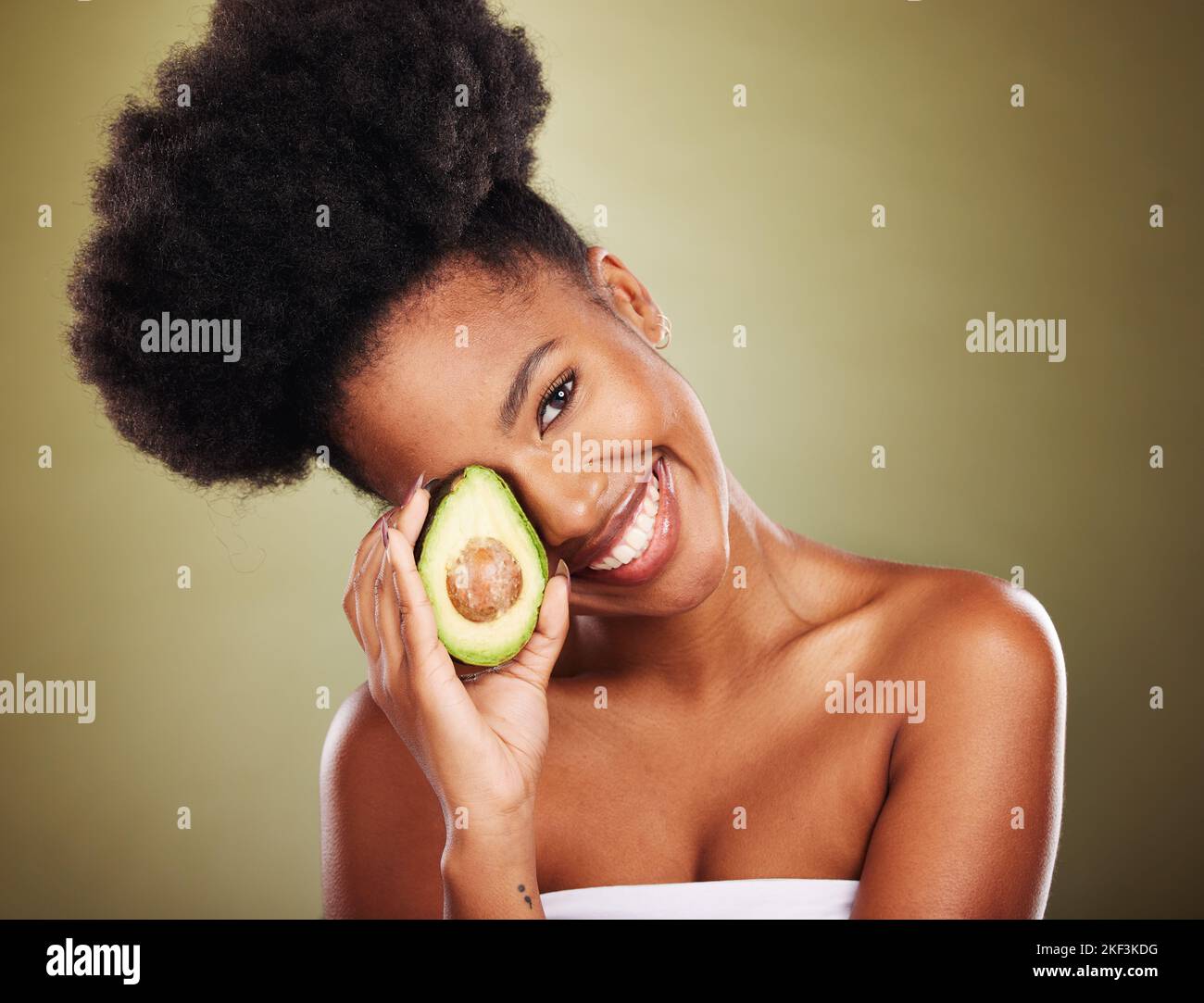 Black woman, skincare and beauty in studio with avocado for health, nutrition or moisturizer for wellness. Woman, model and fruit for radiant glow Stock Photo