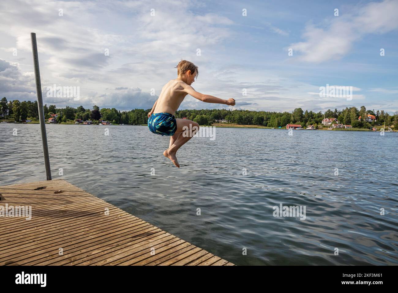 Boy in mid air while diving into lake Stock Photo Alamy