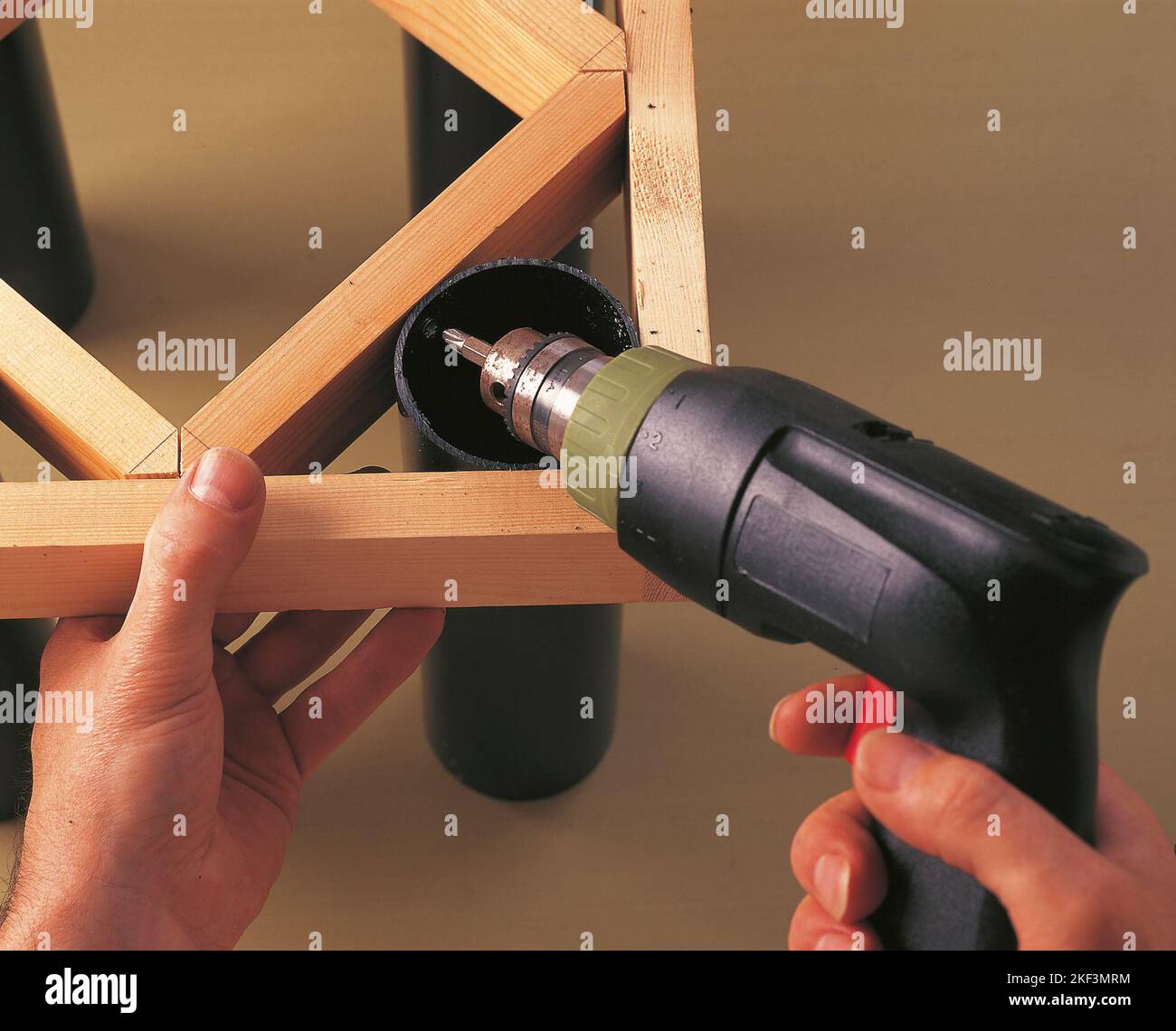 Drilling a screwing a tubular leg to an inner support strut Stock Photo